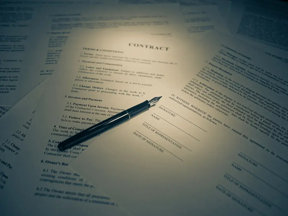 Documentos de contrato en inglés sobre una mesa con un bolígrafo