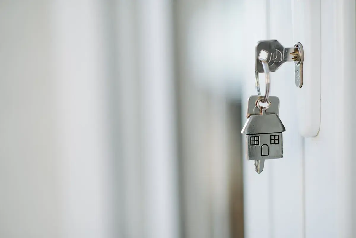 Llave con llavero en forma de casa introducida en una cerradura