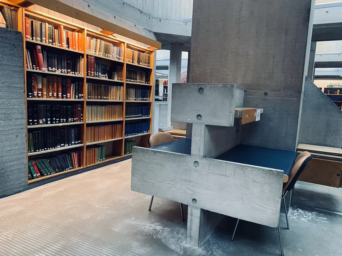 Puesto de estudio vacío y estanterías con libros en una biblioteca