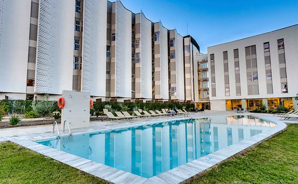 Piscina y edificio de la residencia Livensa Living Granada Cartuja